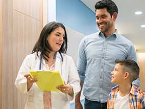 Dad and his son talking with the doctor.